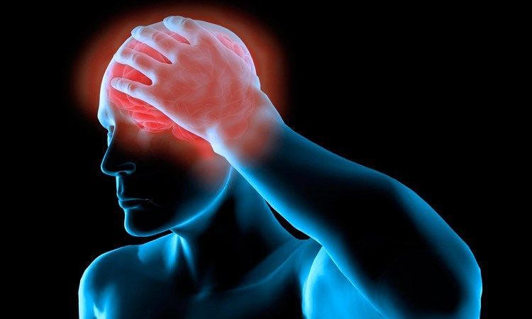 A man is holding his head in pain because of a headache.