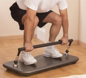 A man squatting on a exercise machine holding a bar