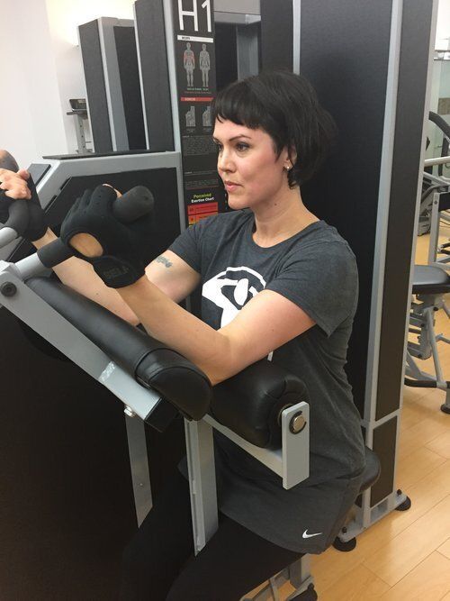 A woman is using a machine in a gym.