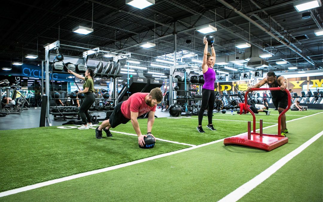 A group of people are doing exercises in a gym.