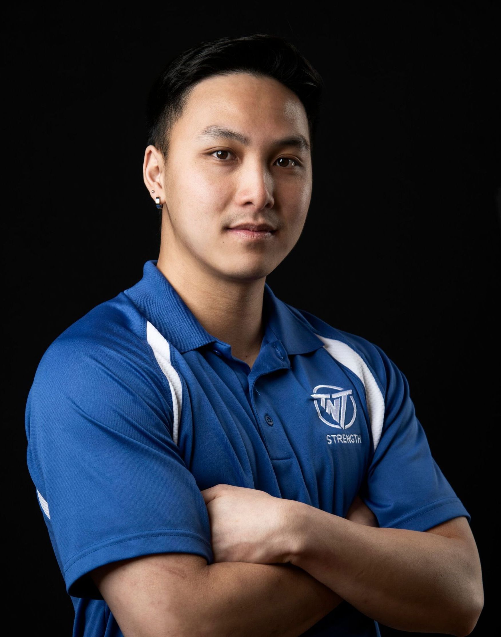 Eric Fong, Strength Coach at TNT Strength in a TNT Strength blue jacket.