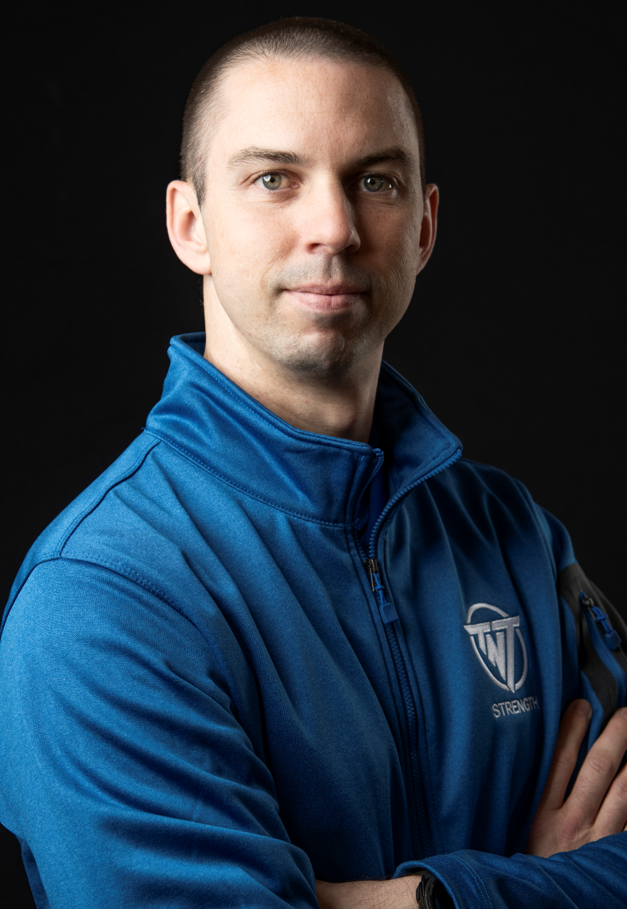 Jesse Schmidt, Co-Owner and CEO at TNT Strength in a TNT Strength blue jacket.