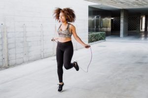 A woman is jumping a jump rope in a parking lot.