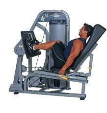 A man is using a leg press machine in a gym.