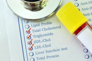 A stethoscope is sitting on top of a cholesterol test