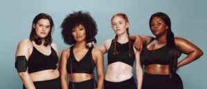 A group of women are standing next to each other in black sports bras.