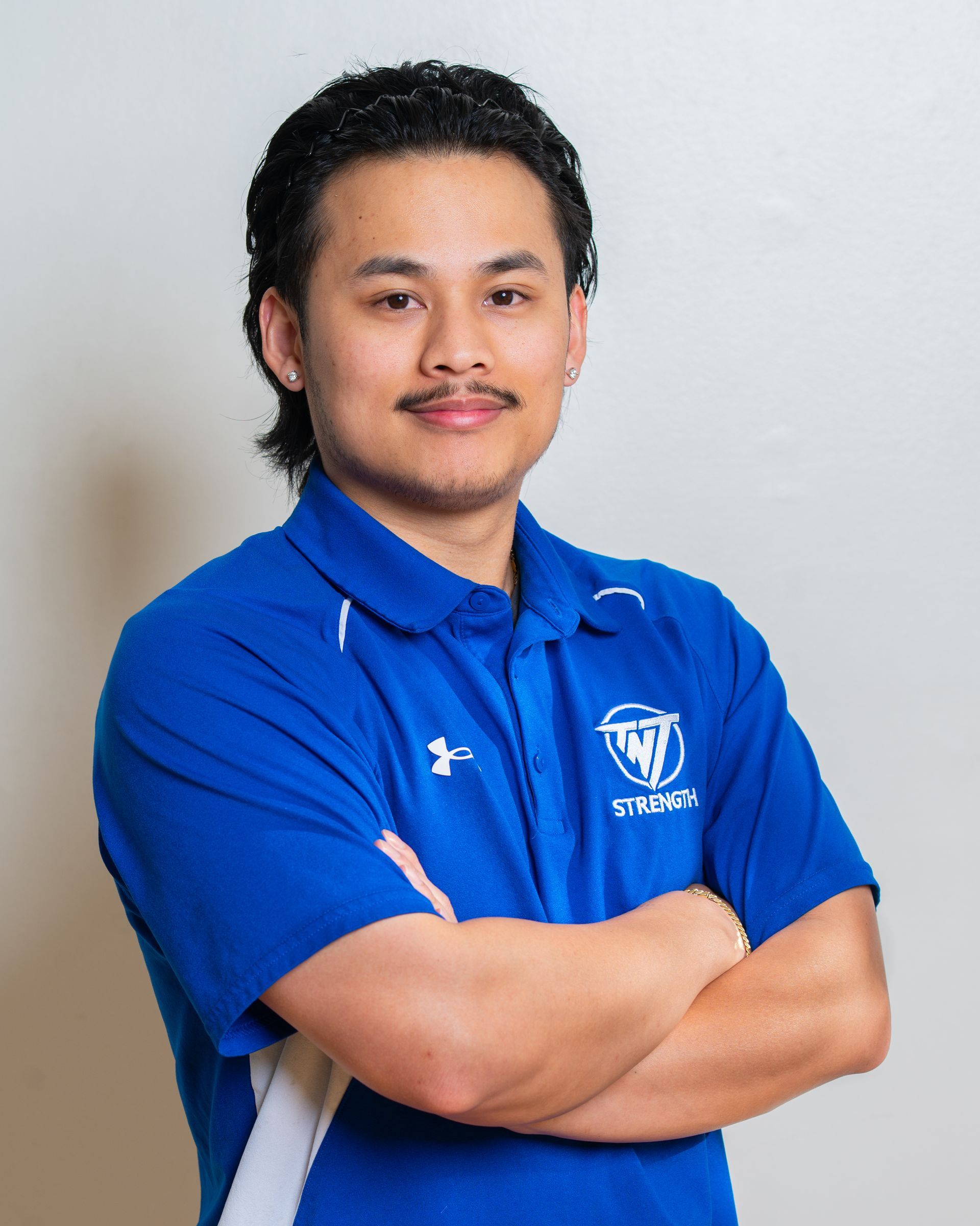 Ryan Salcedo, Strength Coach at TNT Strength in a TNT Strength blue jacket.