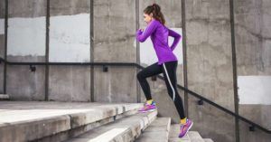 A woman is running up a set of stairs.