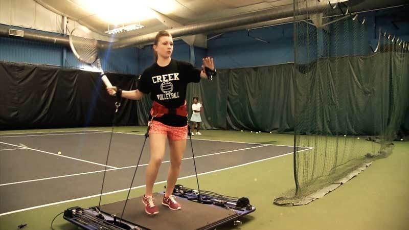 A girl wearing a shirt that says creek is holding a tennis racquet