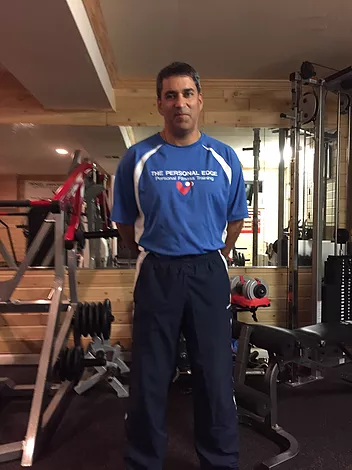 A man in a blue shirt is standing in a gym