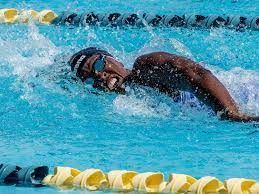 A man is swimming in a swimming pool.