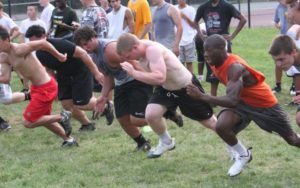 A group of men are running on a grassy field.