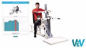 A man is sitting on a machine next to a graph.