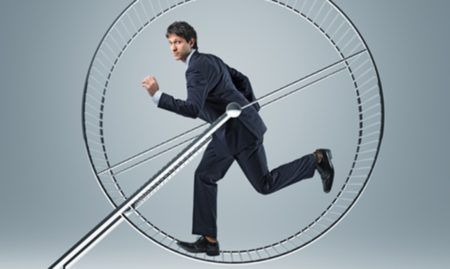 A man in a suit is running in a hamster wheel.