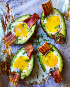 Four avocado slices filled with eggs and bacon