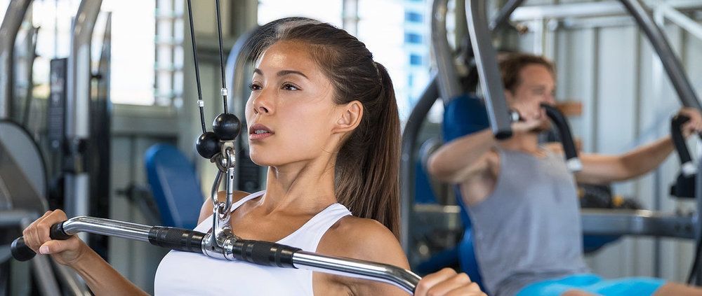 A woman is using a machine in a gym.