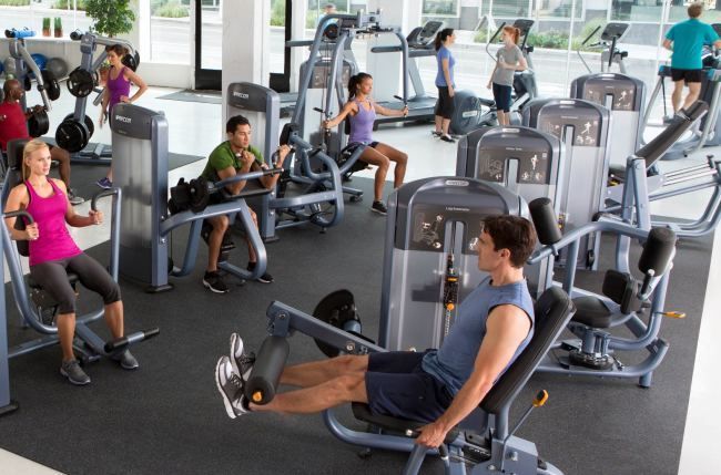 A man is using a leg extension machine in a gym