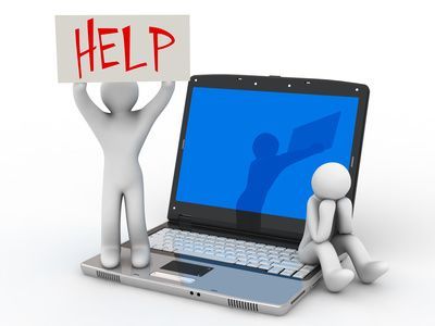 A man is holding a help sign next to a laptop