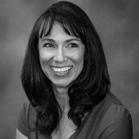 A woman is smiling in a black and white photo.