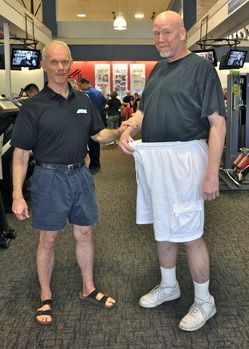 Two men are standing next to each other in a gym.