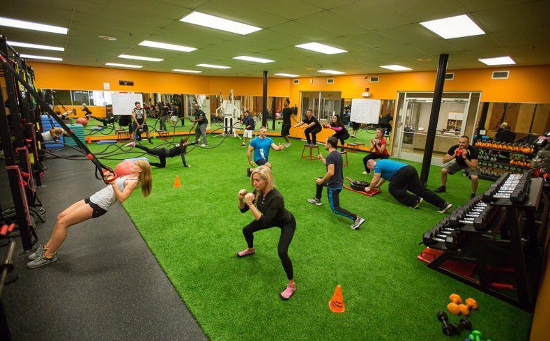 A group of people are doing exercises in a gym.