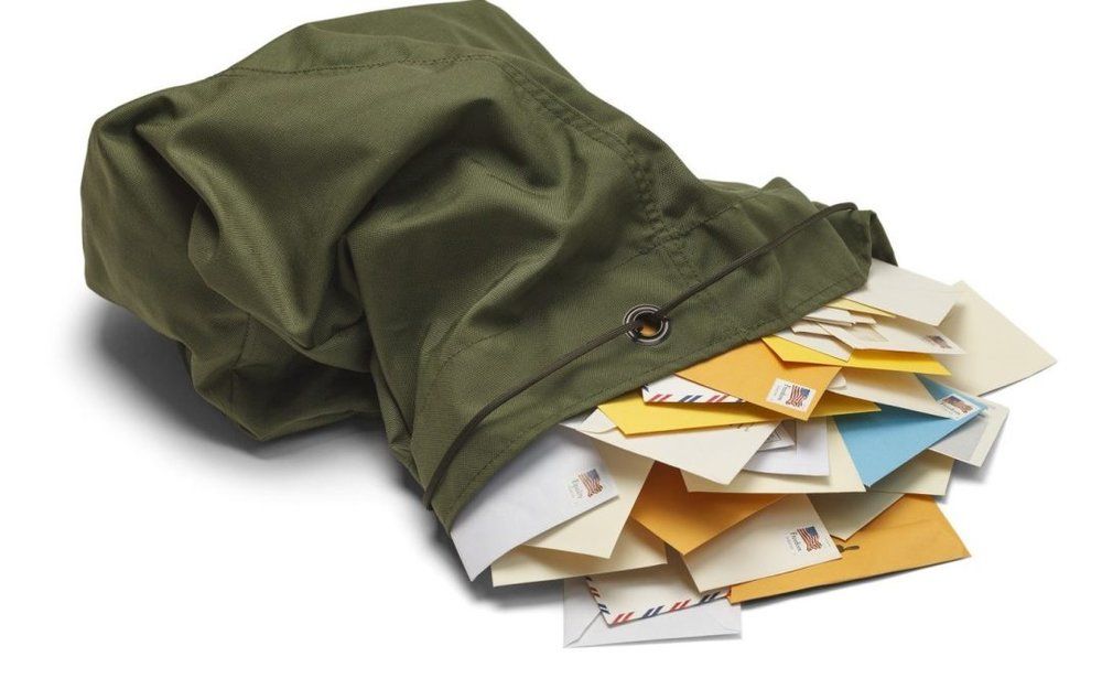 A green bag filled with envelopes including one with the letter r on it