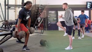 A man is lifting dumbbells in a gym next to a group of people.