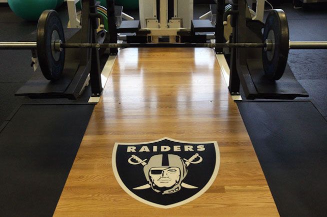 A gym with a raiders logo on the floor