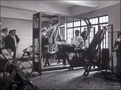 A black and white photo of people in a gym