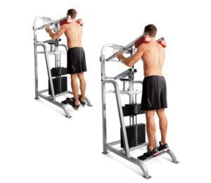 A man is doing a pull up on a machine.