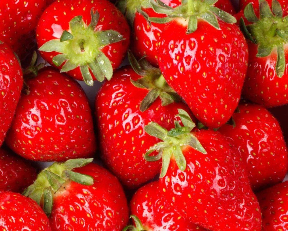 A bunch of red strawberries with green stems