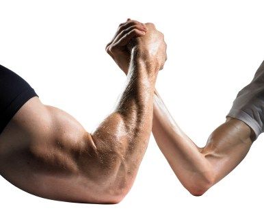 A man and a woman arm wrestling with their arms crossed