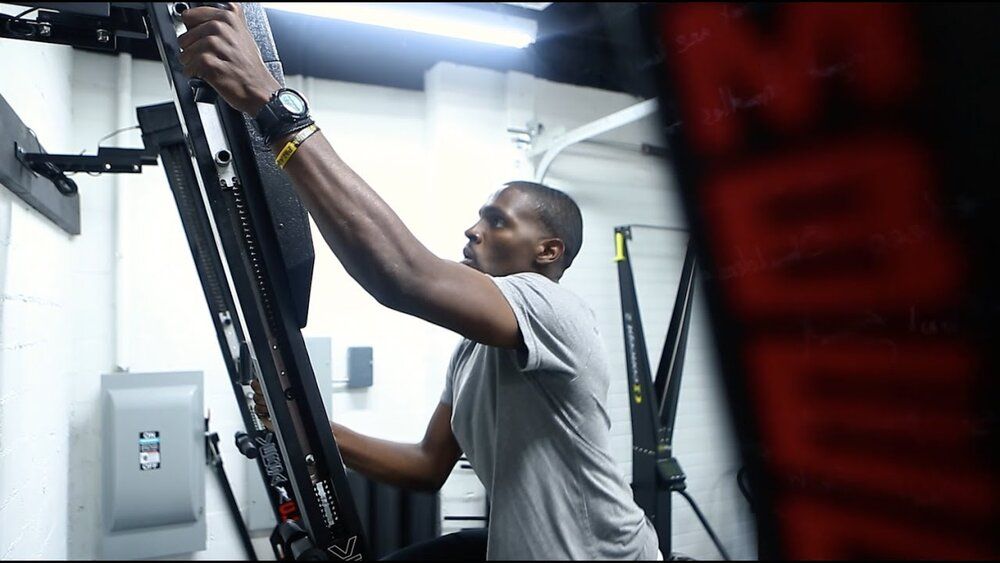 A man is working on a machine in a gym