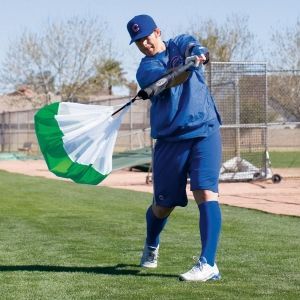 A baseball player is holding a green and white parachute