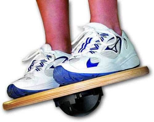 A person is standing on a balance board with their feet on it.