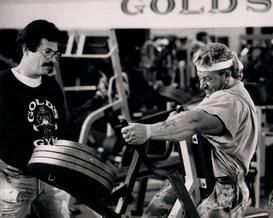 Two men are standing next to each other in a gym.