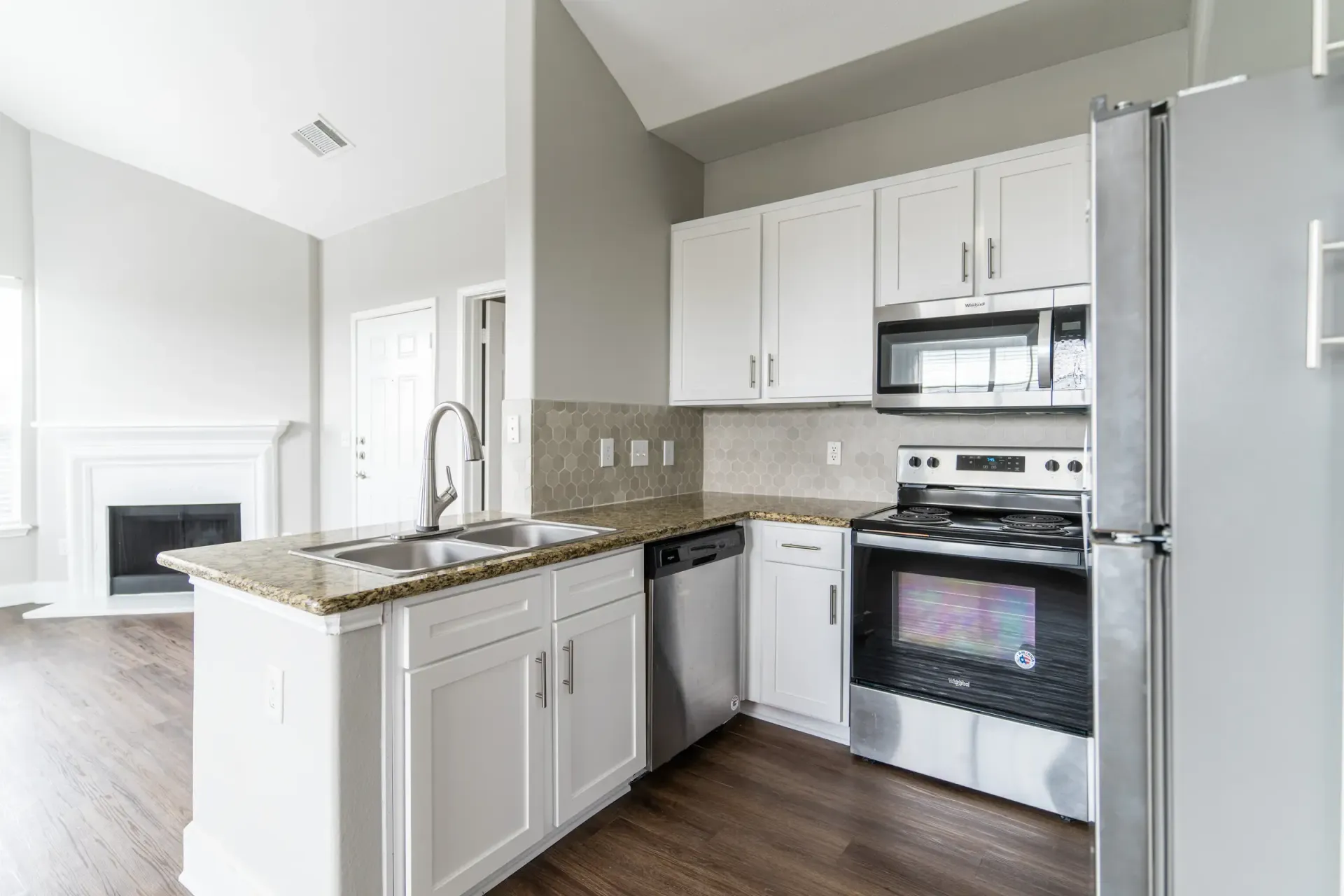 Kitchen with white cabinets, stainless steel appliances, and granite countertops.