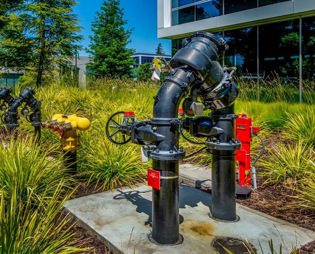 A fire hydrant is sitting in the grass in front of a building.