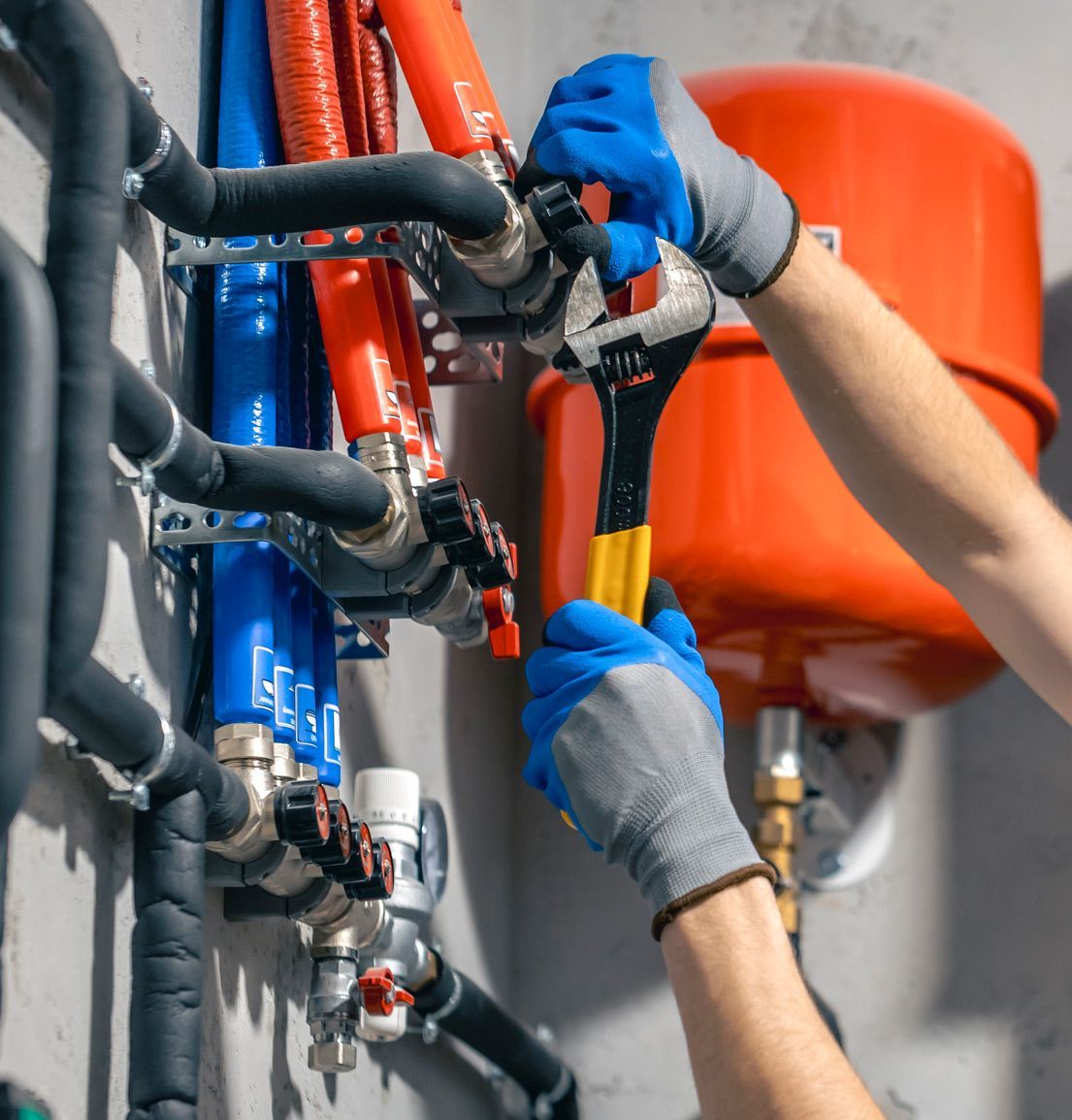 A person is working on a pipe with a wrench.