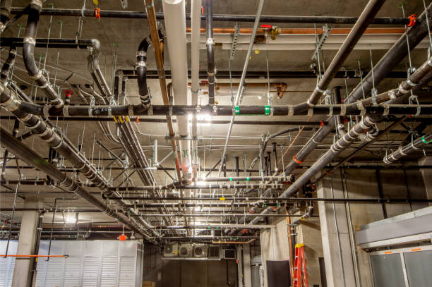 A man is fixing a pipe with a wrench