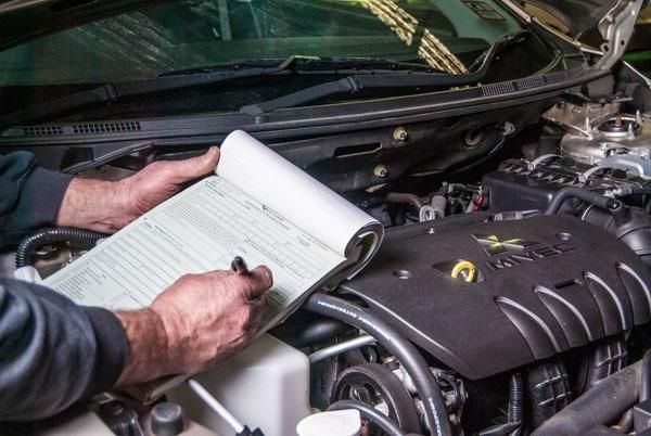 A Man Writing on A Notepad — Envy Automotive in Gorokan, NSW