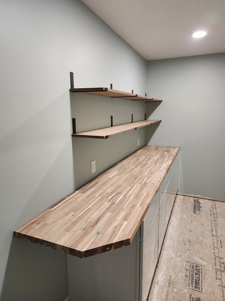 Wooden shelves and countertop on light blue wall. Black metal brackets.