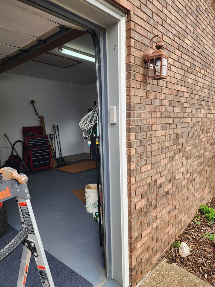 Open garage doorway; brick exterior with light fixture.