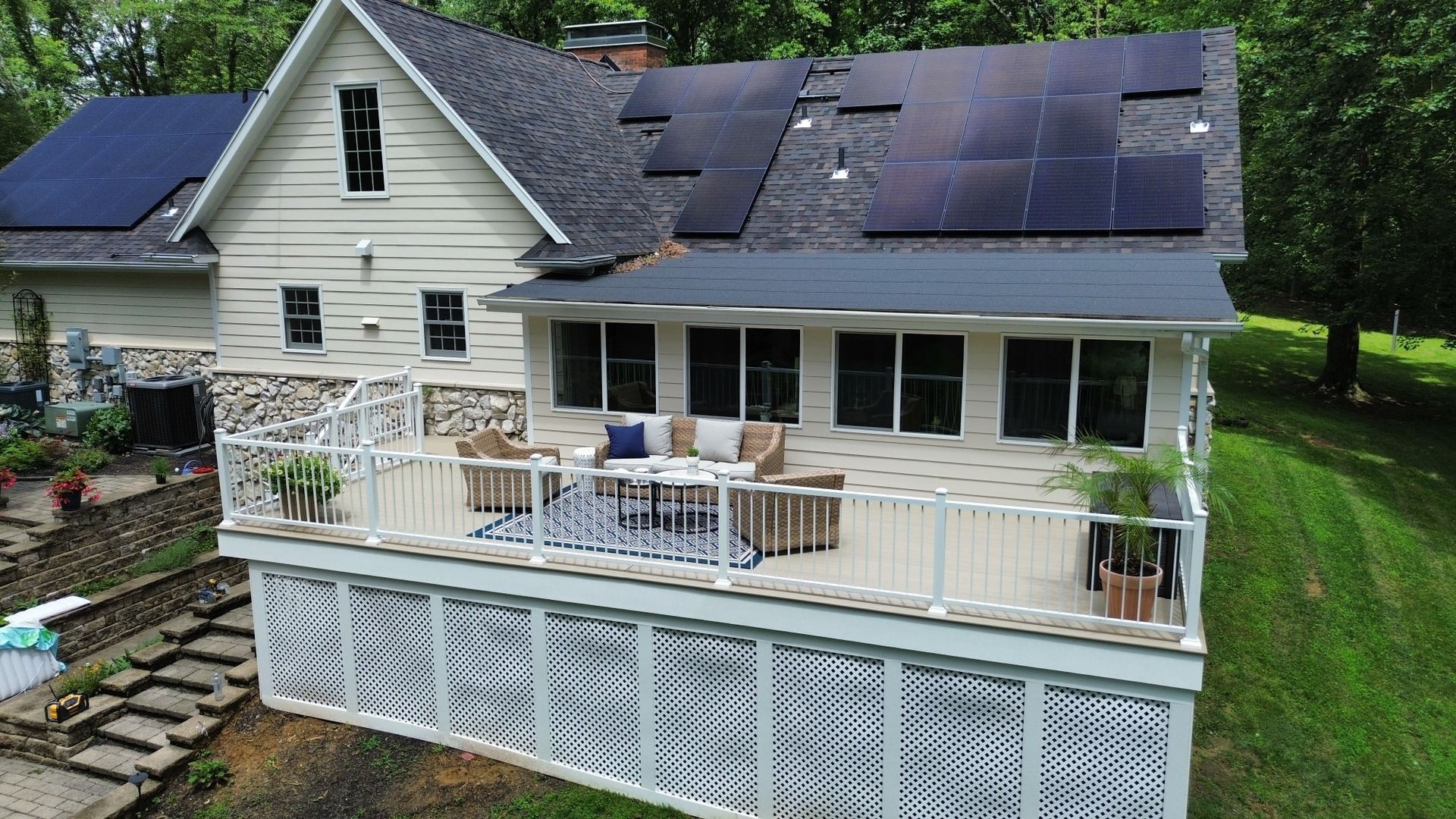 A house with solar panels on the roof and a large deck.