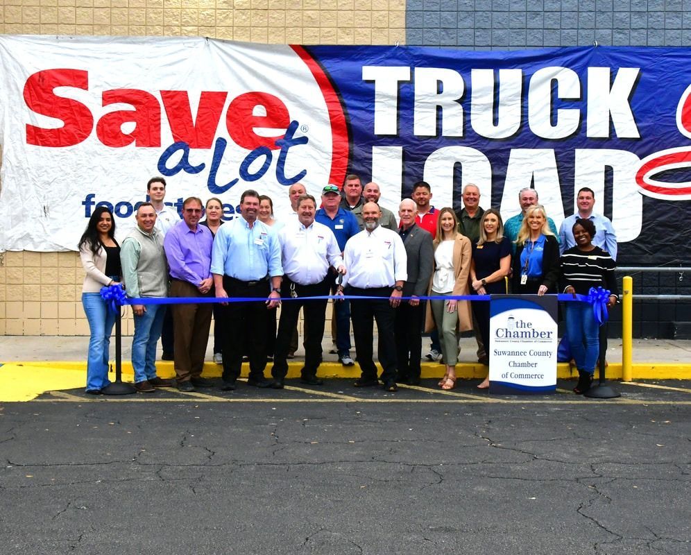 People cutting a ribbon at a Save A Lot grocery store opening. 