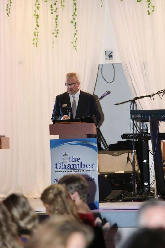 Man in suit speaking at a podium with 