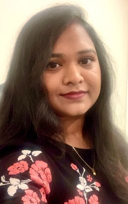 A close up of a woman 's face wearing a floral shirt and necklace.