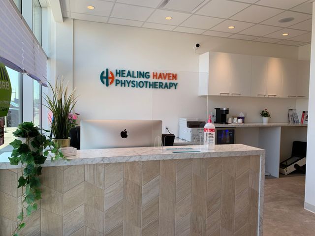Healing Haven Physiotherapy reception desk with logo, computer, plants, and bright modern lobby