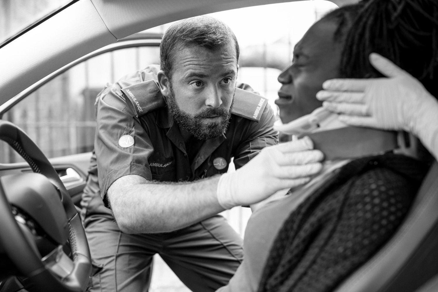 A man is talking to a woman in a car.