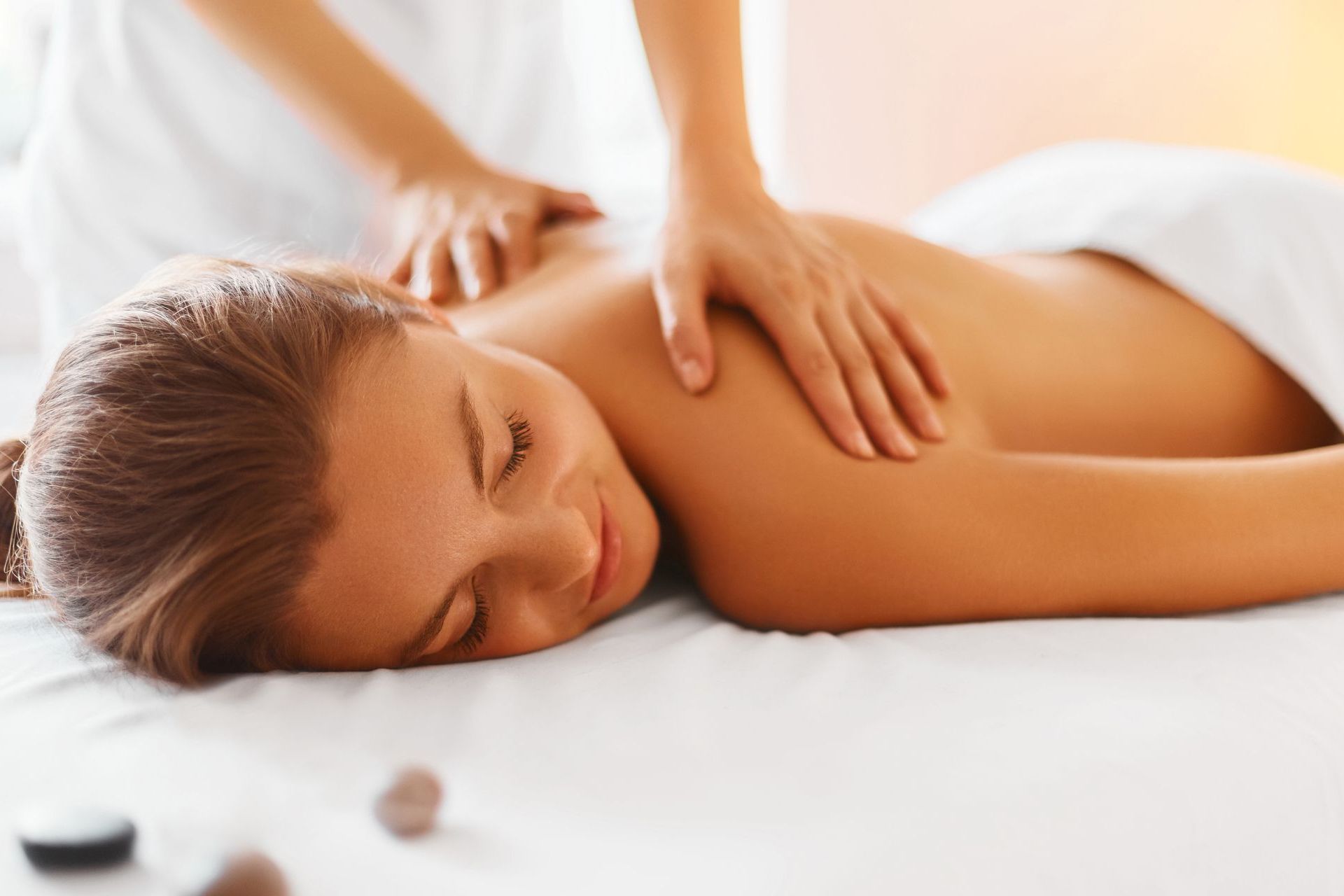 A woman is laying on a bed getting a massage.